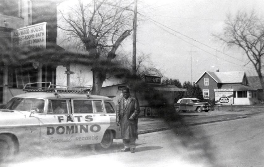 Antoine ‘Fats’ Domino beside Imperial Records tour car on Main Street, North Gower near Ashwood House, April 1957. – Rideau Archives, Elsie Hyland collection. – Photographer: Elsie Hyland